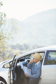 Älterer Mann prüft Karte im Auto - CAIF16920
