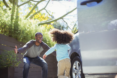 Begeisterter Vater, der seine Tochter vor dem Auto begrüßt - CAIF16921