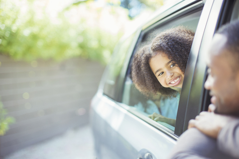 Vater und Tochter lehnen sich aus dem Autofenster, lizenzfreies Stockfoto