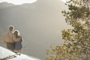 Senior couple looking at mountain view outside car - CAIF16927