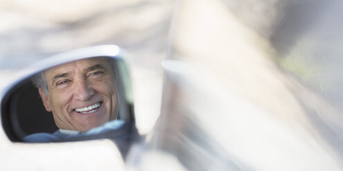 Reflection of smiling senior man in side-view car mirror - CAIF16931