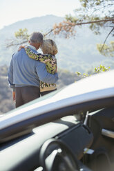 Senior couple looking at mountain view outside car - CAIF16934
