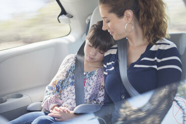 Mother and daughter sleeping in back seat of car - CAIF16953