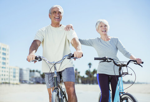 Älteres Paar mit Fahrrädern am Strand - CAIF16969
