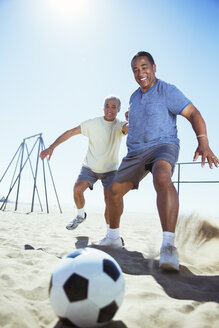 Ältere Männer spielen Fußball am Strand - CAIF16971