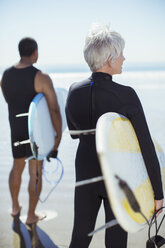 Älteres Paar mit Surfbrettern am Strand - CAIF16973