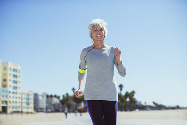 Senior woman power walking on beach - CAIF16979