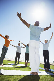 Senioren üben Yoga im sonnigen Park - CAIF16990