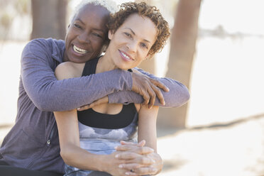 Smiling women hugging outdoors - CAIF16996