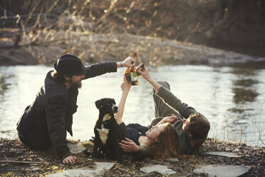 Friends enjoying drink at riverbank - CAVF08829