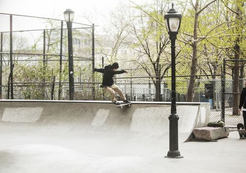 Mann übt Skateboardfahren im Skateboardpark, lizenzfreies Stockfoto