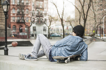 Rückansicht eines Mannes, der sich auf einem Sitz in einem Skateboard-Park entspannt - CAVF08866