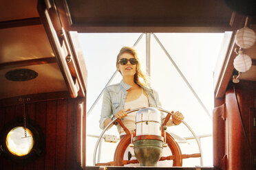 Frau mit Sonnenbrille beim Segeln auf einer Yacht - CAVF08922