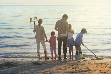 Familie reinigt Strand bei Sonnenuntergang - CAVF09039