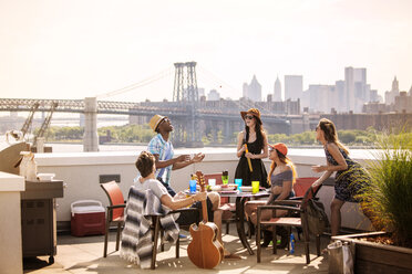 Freunde vergnügen sich auf der Terrasse des Gebäudes an der Williamsburg Bridge - CAVF09041