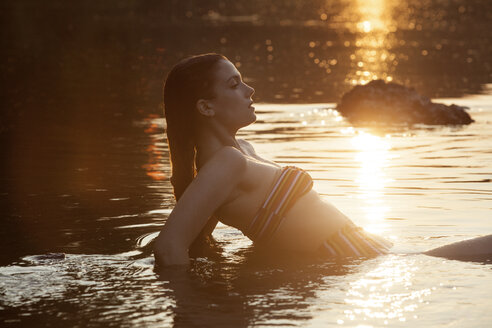 Seitenansicht einer Frau im See bei Sonnenaufgang - CAVF09130