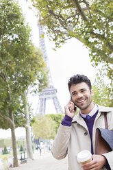 Geschäftsmann, der in der Nähe des Eiffelturms mit einem Handy telefoniert, Paris, Frankreich - CAIF17011