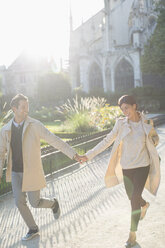 Couple holding hands in urban park - CAIF17066