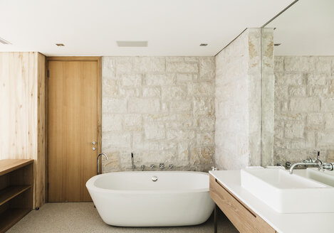 Steinwände hinter der Badewanne in einem modernen Badezimmer - CAIF17100