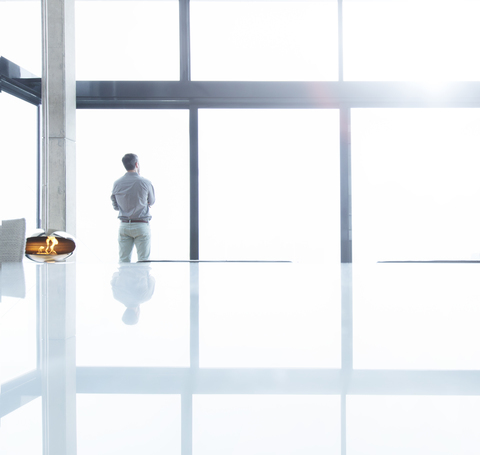 Businessman standing at office window stock photo