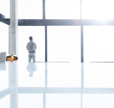 Geschäftsmann steht am Bürofenster, lizenzfreies Stockfoto