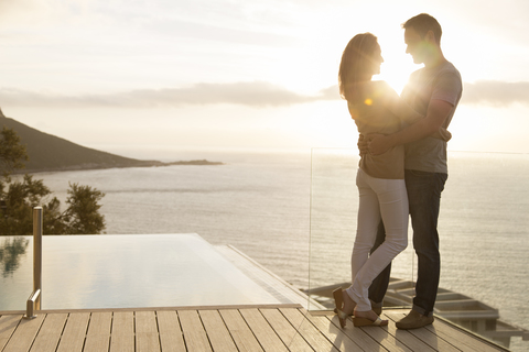 Couple on wooden deck overlooking ocean stock photo
