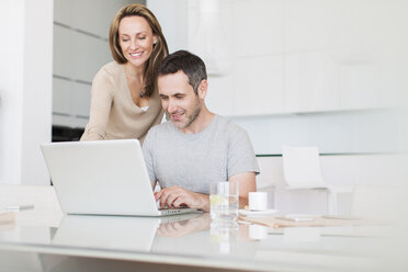 Couple using laptop at breakfast table - CAIF17153