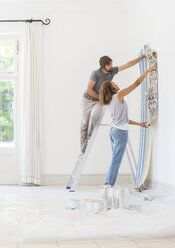 Couple hanging wallpaper together - CAIF17242