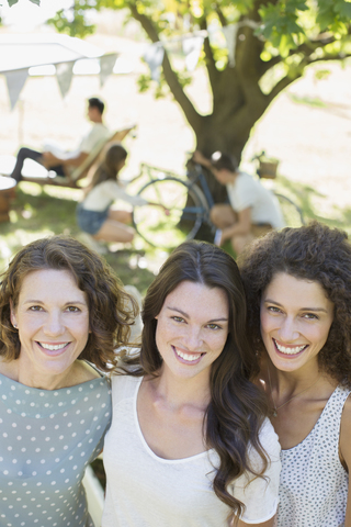 Drei Frauen umarmen sich im Freien, lizenzfreies Stockfoto