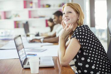 Woman working at conference table in office - CAIF17319