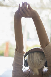 Woman stretching in headphones - CAIF17387