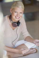 Frau benutzt digitales Tablet auf Sofa - CAIF17388