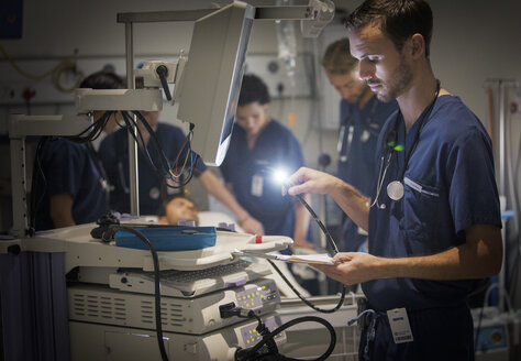 Eine Gruppe von Ärzten kümmert sich um einen Patienten in einer Krankenhausabteilung - CAIF17396