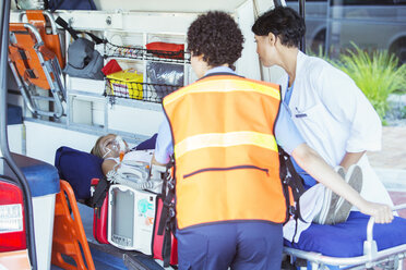 Paramedics wheeling patient out of ambulance - CAIF17432