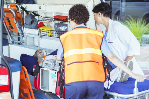 Paramedics wheeling patient out of ambulance - CAIF17432
