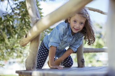 Mädchen klettert im Baumhaus im Freien - CAIF17452