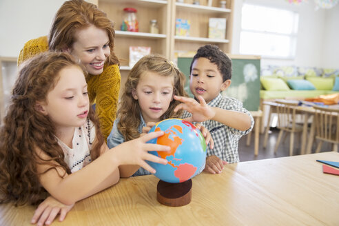 Schüler und Lehrer untersuchen den Globus im Klassenzimmer - CAIF17453