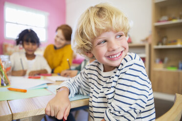 Lächelnder Schüler im Klassenzimmer - CAIF17459