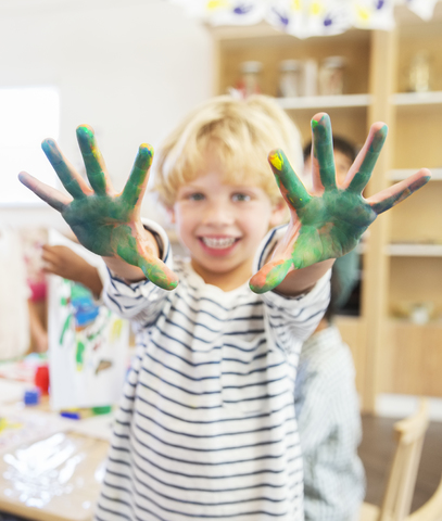 Ein Schüler zeigt seine schmutzigen Hände im Klassenzimmer, lizenzfreies Stockfoto