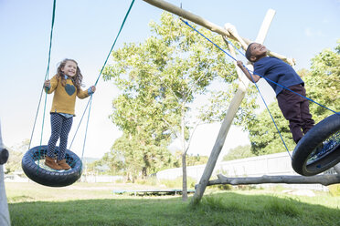 Children playing on tire swings - CAIF17468