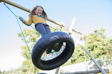 Girl playing on tire swing - CAIF17469