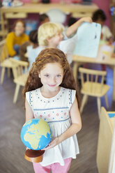 Schüler hält Globus im Klassenzimmer - CAIF17474