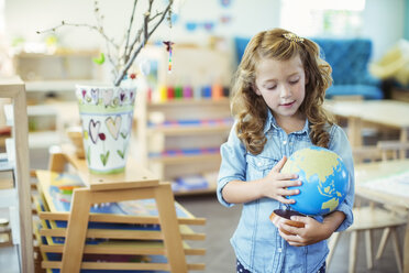 Ein Schüler untersucht einen Globus im Klassenzimmer - CAIF17481