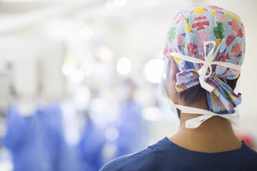 Rückansicht einer jungen Krankenschwester, die im Operationssaal steht - CAIF17496