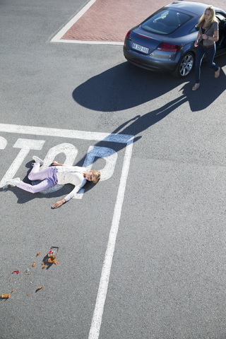 Fahrer eilt zu verletztem Mädchen auf der Straße, lizenzfreies Stockfoto
