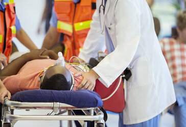 Arzt untersucht einen Patienten auf einer Bahre - CAIF17510