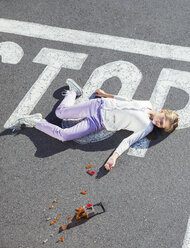 Injured girl laying in street - CAIF17512