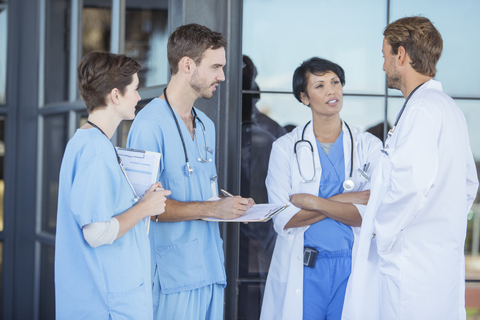 Gespräche zwischen Ärzten und Krankenschwestern vor dem Krankenhaus, lizenzfreies Stockfoto