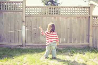 Baby girl playing with string in backyard - CAIF17525