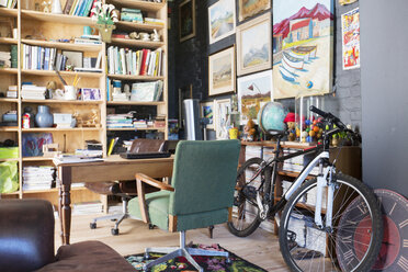 Schreibtisch, Bücherregale und Fahrrad im Arbeitszimmer - CAIF17528
